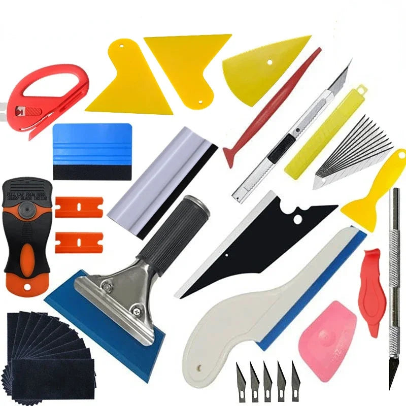 A collection of professional car vinyl wrap tools including cutters, blades, and shaping tools.
