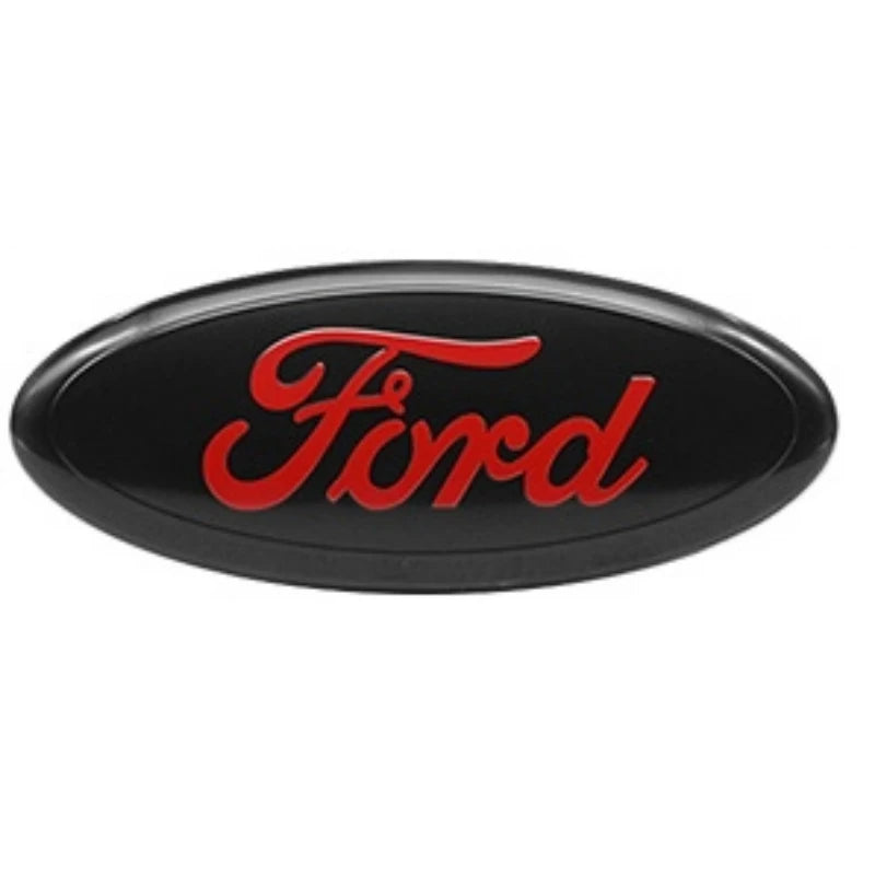 Emblème de voiture ovale noire avec le mot Ford écrit en écriture rouge.