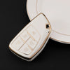 A white multi-function car key cover with various buttons rests on a black surface.