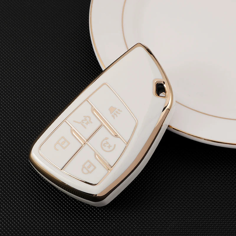 A white multi-function car key cover with various buttons rests on a black surface.