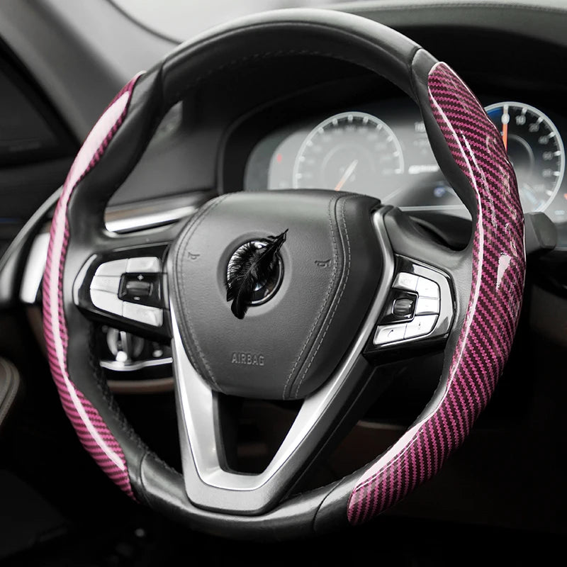 Gros plan d'un volant noir recouvert de matériau en fibre de carbone rose et noir.