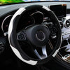 A black steering wheel with a white PU carbon fiber cover is visible inside a car's interior.