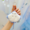 A hand holds a small, light blue plush bunny keychain with soft fur and a gold ring against a light blue background.