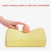 A hand is placing an egg on a yellow memory foam neck pillow.