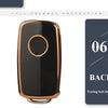A black silicone TPU car key cover protector with a round indentation and gold trim.