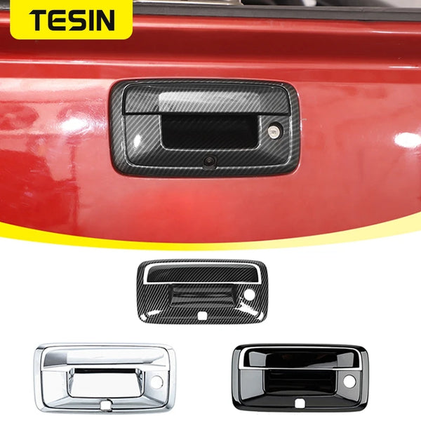 Close-up view of a black carbon fiber tailgate handle trim cover and a chrome tailgate handle.