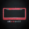 A rectangular license plate frame covered in red crystal rhinestones with a clear plastic cover and mounting hardware.