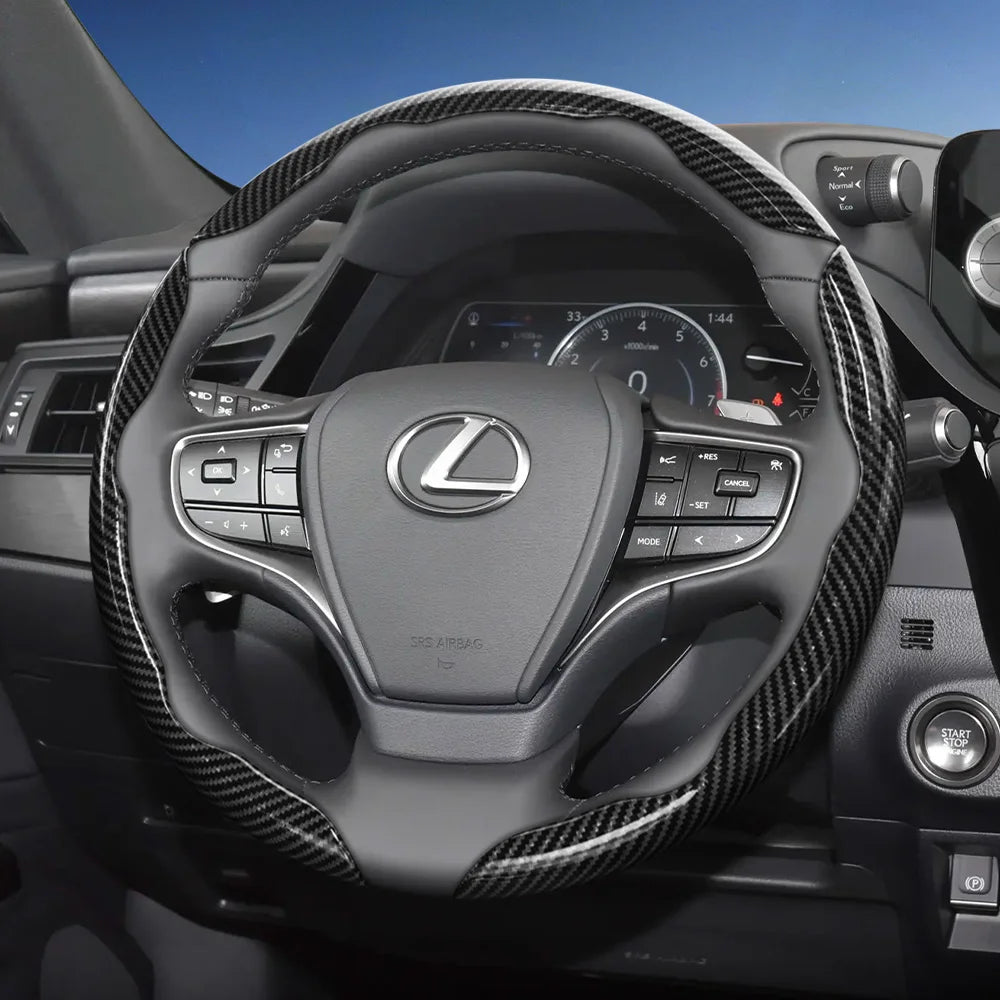 Close-up view of a Lexus steering wheel with carbon fiber patterned covers and controls.