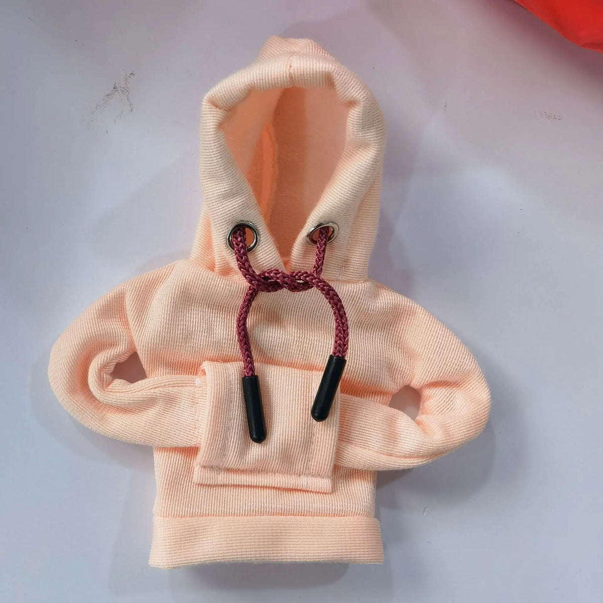 A light peach colored hoodie with a drawstring hood and a patch pocket.