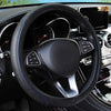 Close-up view of a black leather steering wheel with blue stitching inside a car interior.