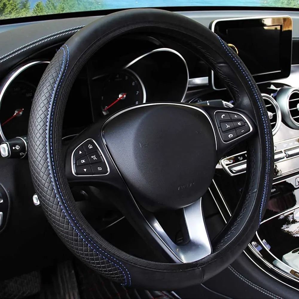 Close-up view of a black leather steering wheel with blue stitching inside a car interior.
