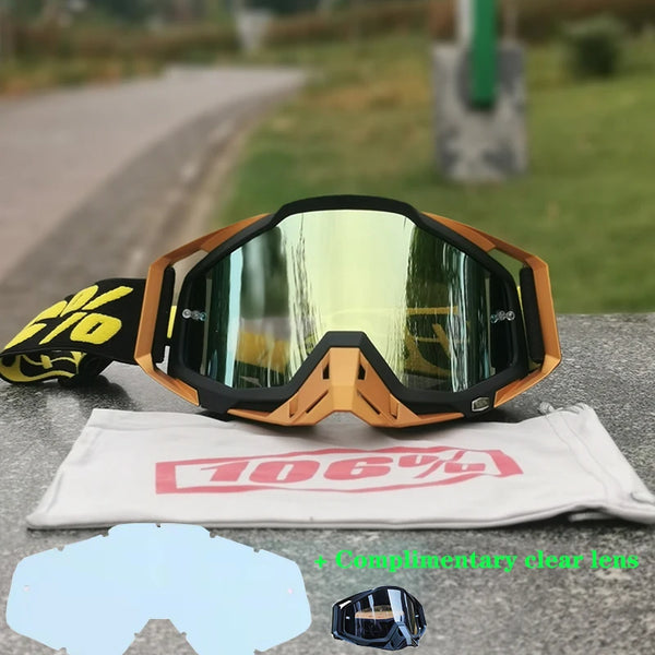 A pair of orange and black motocross goggles resting on a white cloth with a lens insert.