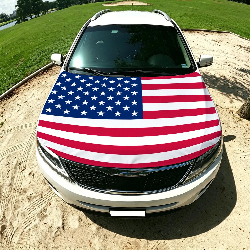 A white car with a patriotic American flag windproof hood cover displayed outdoors on a dirt road.