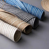 Collection de dessous-de-verre et sets de table ronds tissés dans diverses nuances de bleu, gris, beige et blanc.