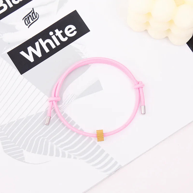 A pink heart-shaped fitness tracker bracelet is shown on a white background next to text that reads White.