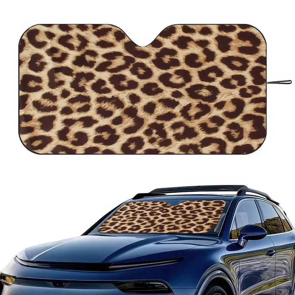 A leopard print car sunshade fitted to the window of a blue car.