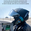 A person wearing a dark motorcycle helmet with an integrated device is shown against a blurred outdoor background.