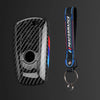 Juego de funda para llave de coche de fibra de carbono negra con cordón azul y rojo y anillo de llaves adjunto.