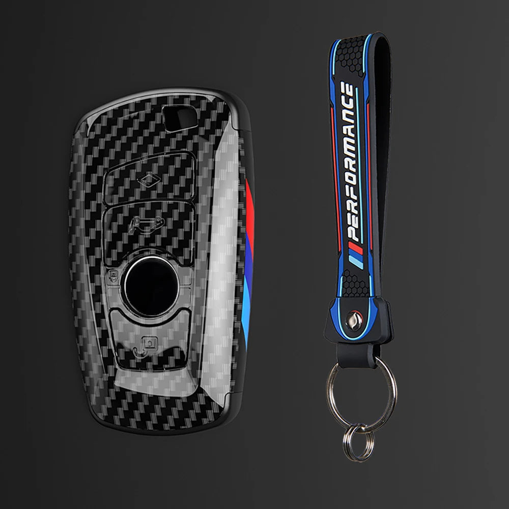 Juego de funda para llave de coche de fibra de carbono negra con cordón azul y rojo y anillo de llaves adjunto.