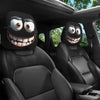 Two black car headrest covers with funny slanted eyes are shown inside a vehicle cabin.