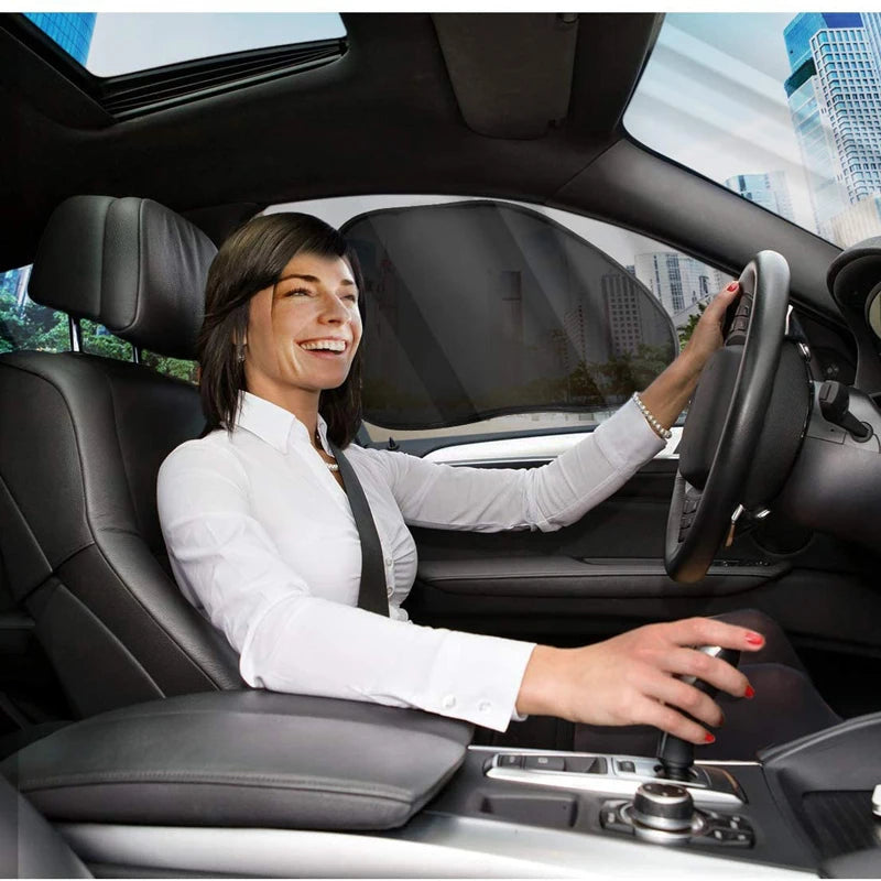 Une femme conduit une voiture avec le pare-soleil du pare-brise visible à l'intérieur.