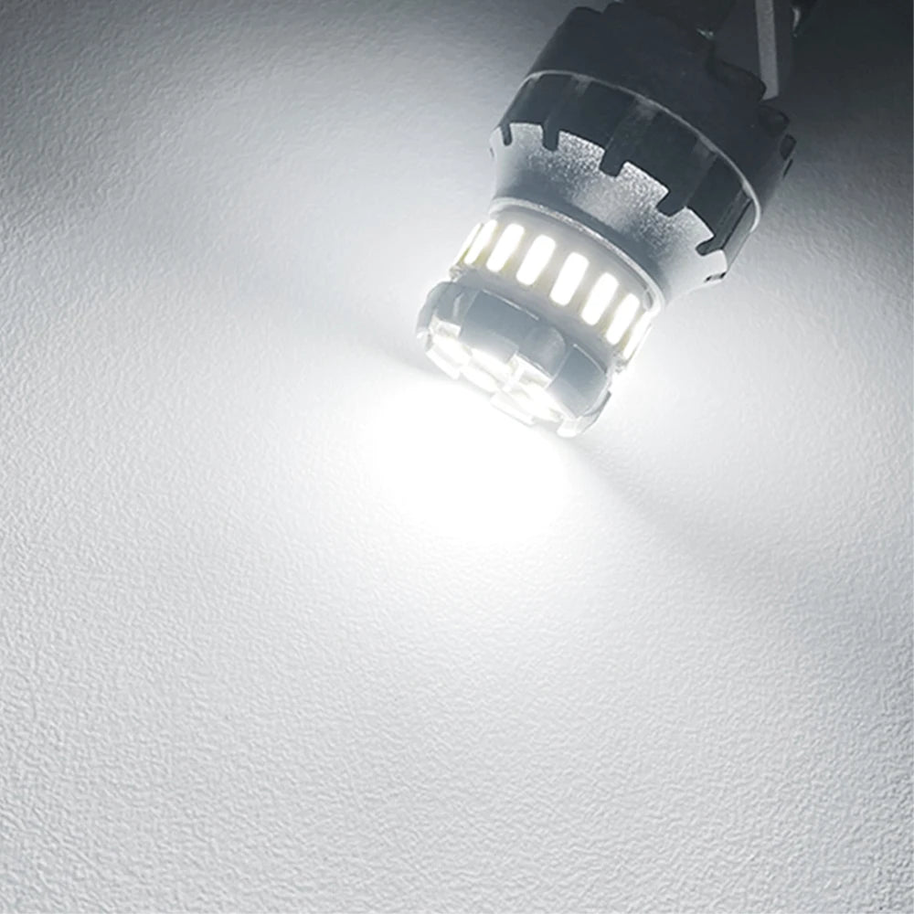 Close-up view of an LED brake and reverse light bulb emitting a bright white illumination.