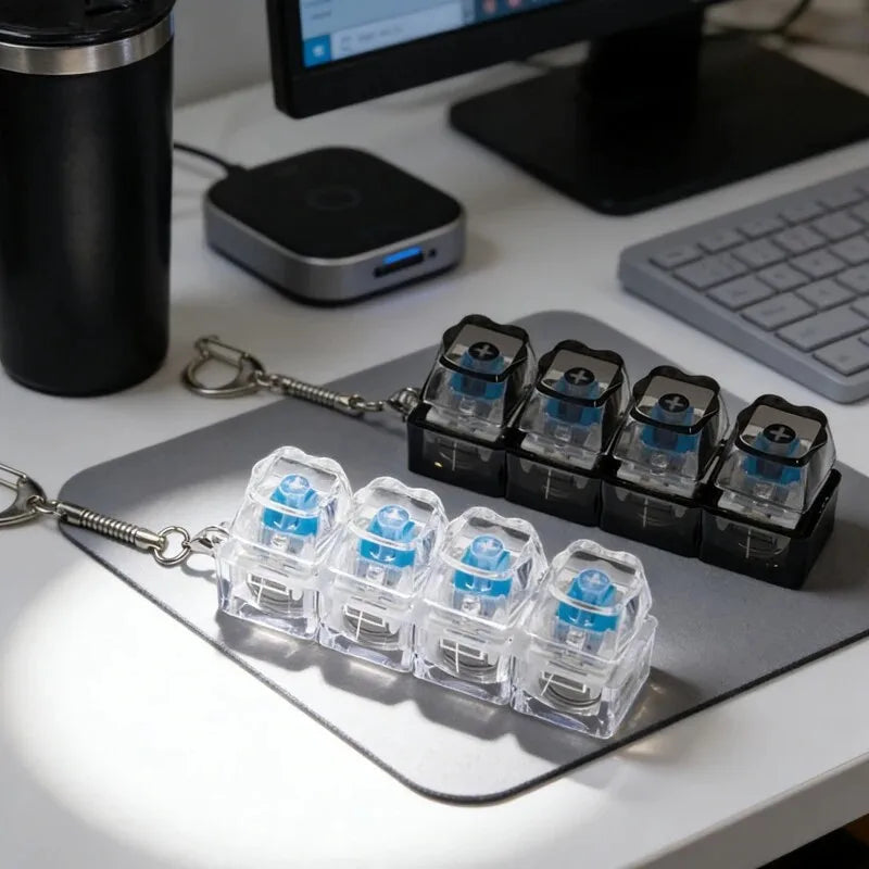 A collection of illuminated mechanical keyboard keychains displayed on a gray silicone mat.
