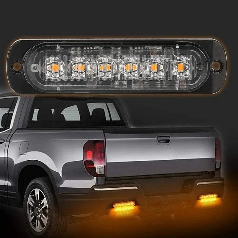 Gros plan sur des feux de détresse doubles installés à l'arrière d'un pick-up argenté.