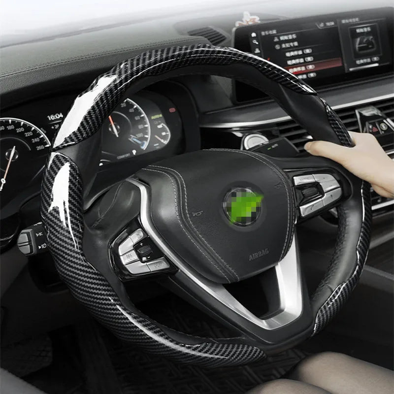 Vue rapprochée d'une housse de protection en fibre de carbone noire installée sur le volant d'une voiture.