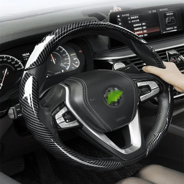 A close-up view of a black carbon fiber steering wheel protector cover installed on a car's steering wheel.