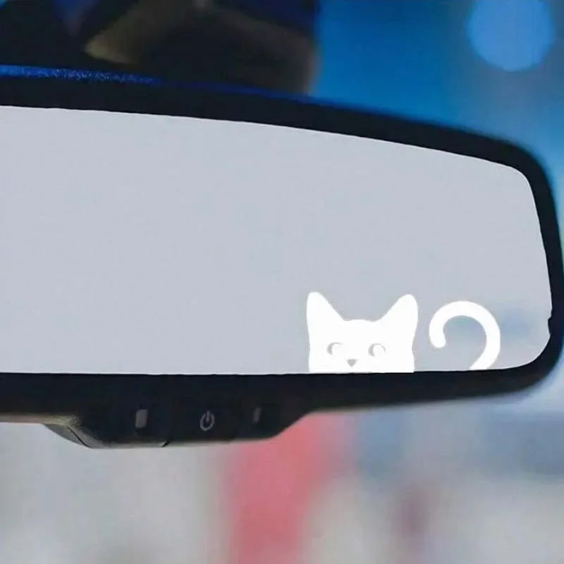White cat decal sticker placed on a black rearview mirror.