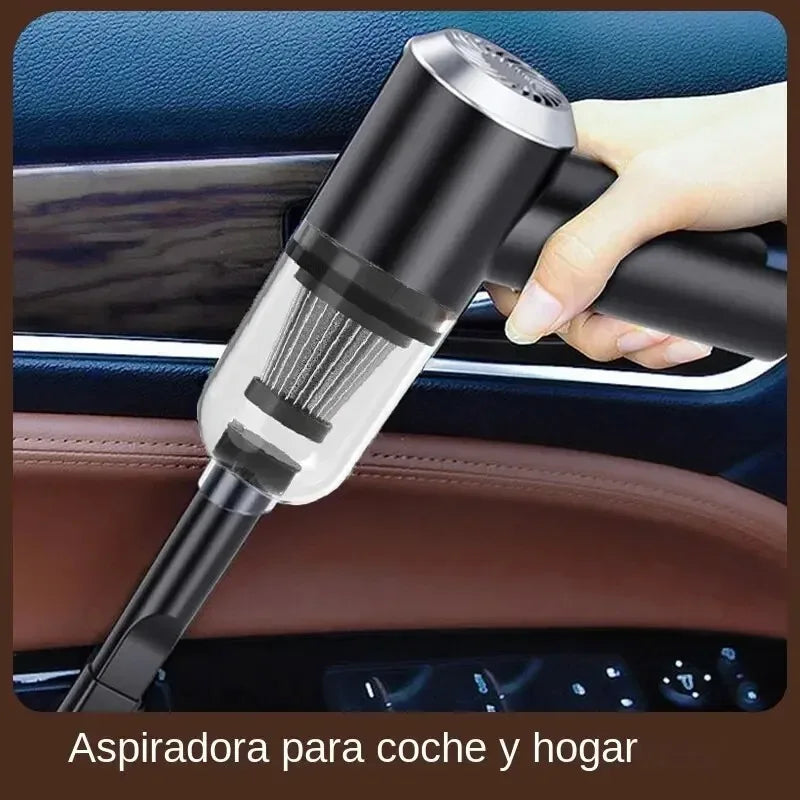 Une main utilise un aspirateur de voiture sans fil noir et transparent dans l'habitacle d'une voiture.