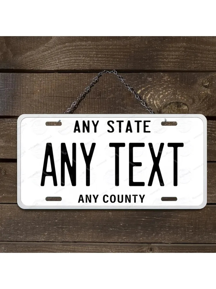 A white aluminum license plate sign with black text reading Any State Any Text and Any County, hanging from a metal chain on 