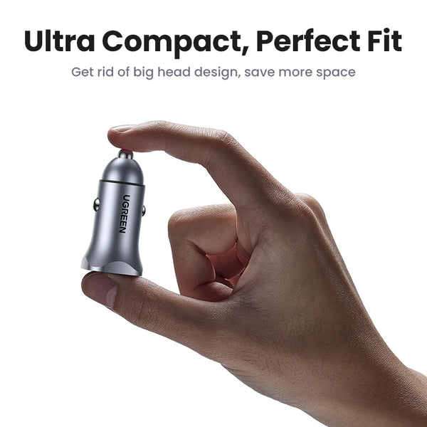 A hand holds a small, silver electronic device, a 30W dual-port USB-C fast car charger.