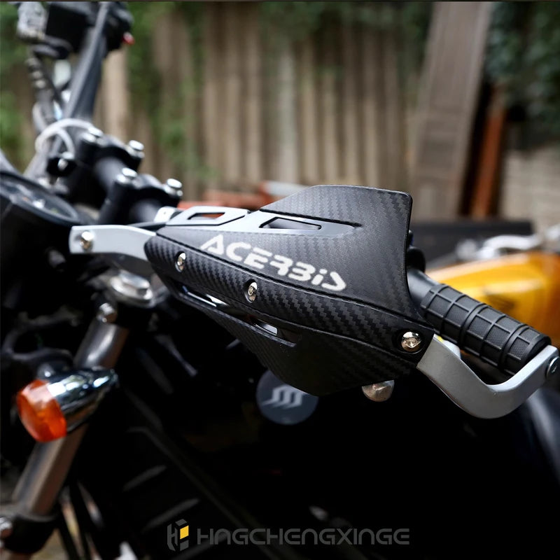 Close-up of a black Acerbis motorcycle handguard protector installed on a dirt bike.
