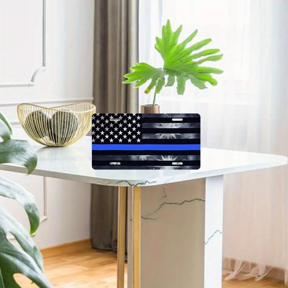 A black and white American flag design displayed on a laptop, set on a white table with a green plant in the background.