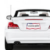 A white car's rear view showing a license plate frame with an American flag design.