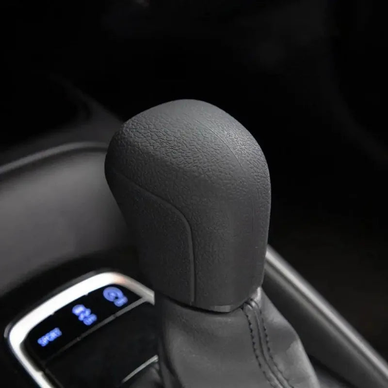 Close-up of a black gear shift knob cover on a car's transmission shifter.