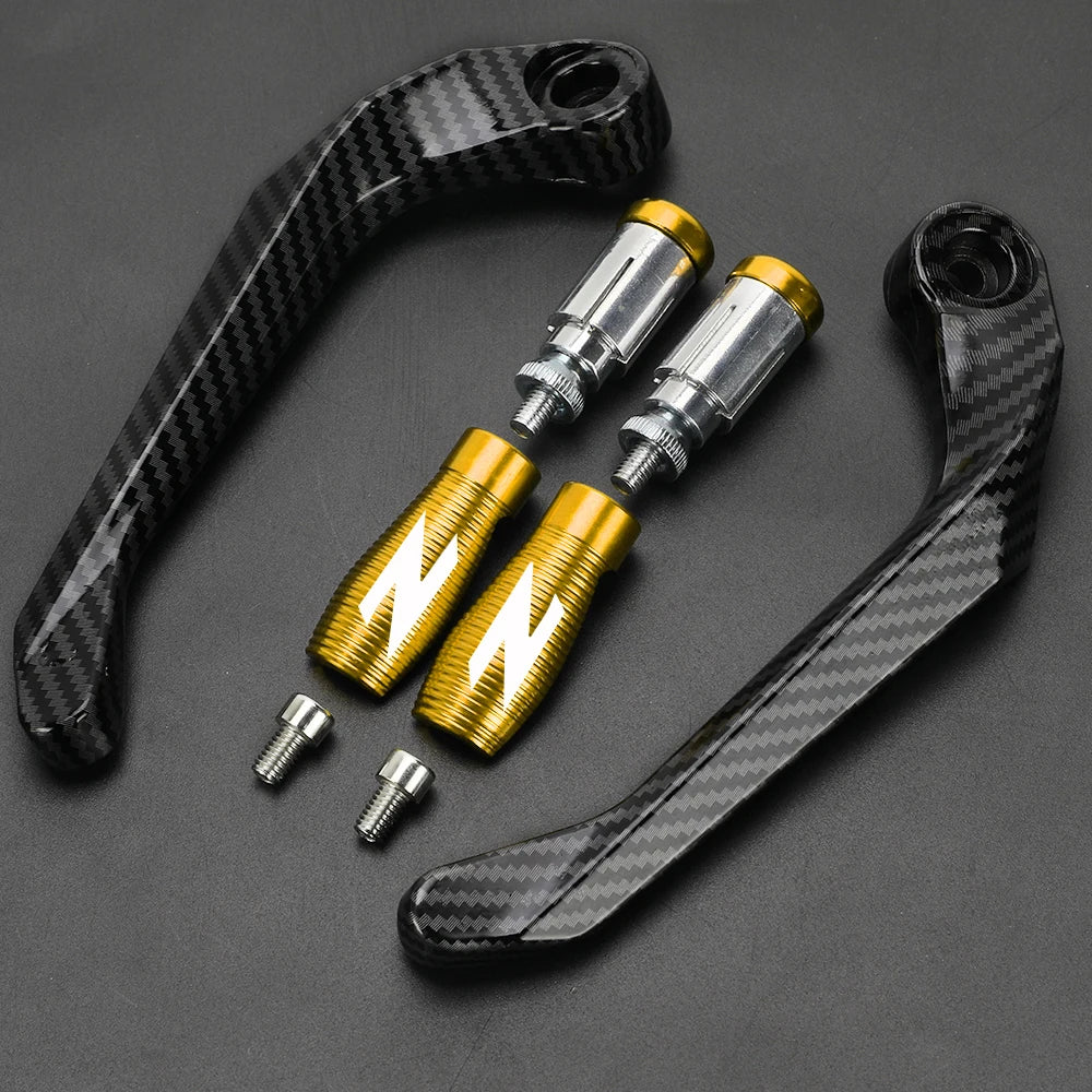 A set of black carbon fiber motorcycle levers and handguard protectors with gold accents.