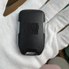 A black aftermarket remote key for a Chevrolet truck or SUV is held in a person's hand.