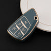 A teal car key cover with multiple function buttons rests on a white plate.