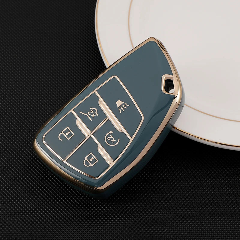 A teal car key cover with multiple function buttons rests on a white plate.