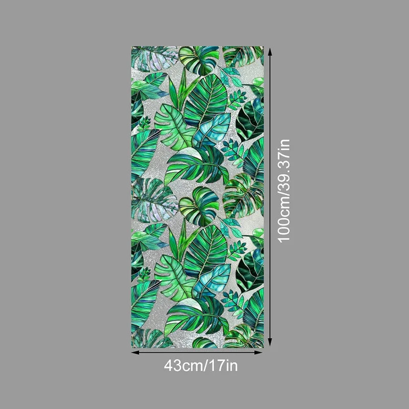 Vertical sheet of decorative PVC stained glass window film featuring lush green tropical leaves on a light gray background
