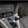 Close-up view of a black universal aluminum gear shift knob installed in a vehicle's interior