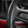 Close-up of black carbon fiber steering wheel covers showing form-fitting appearance and interior refinement.