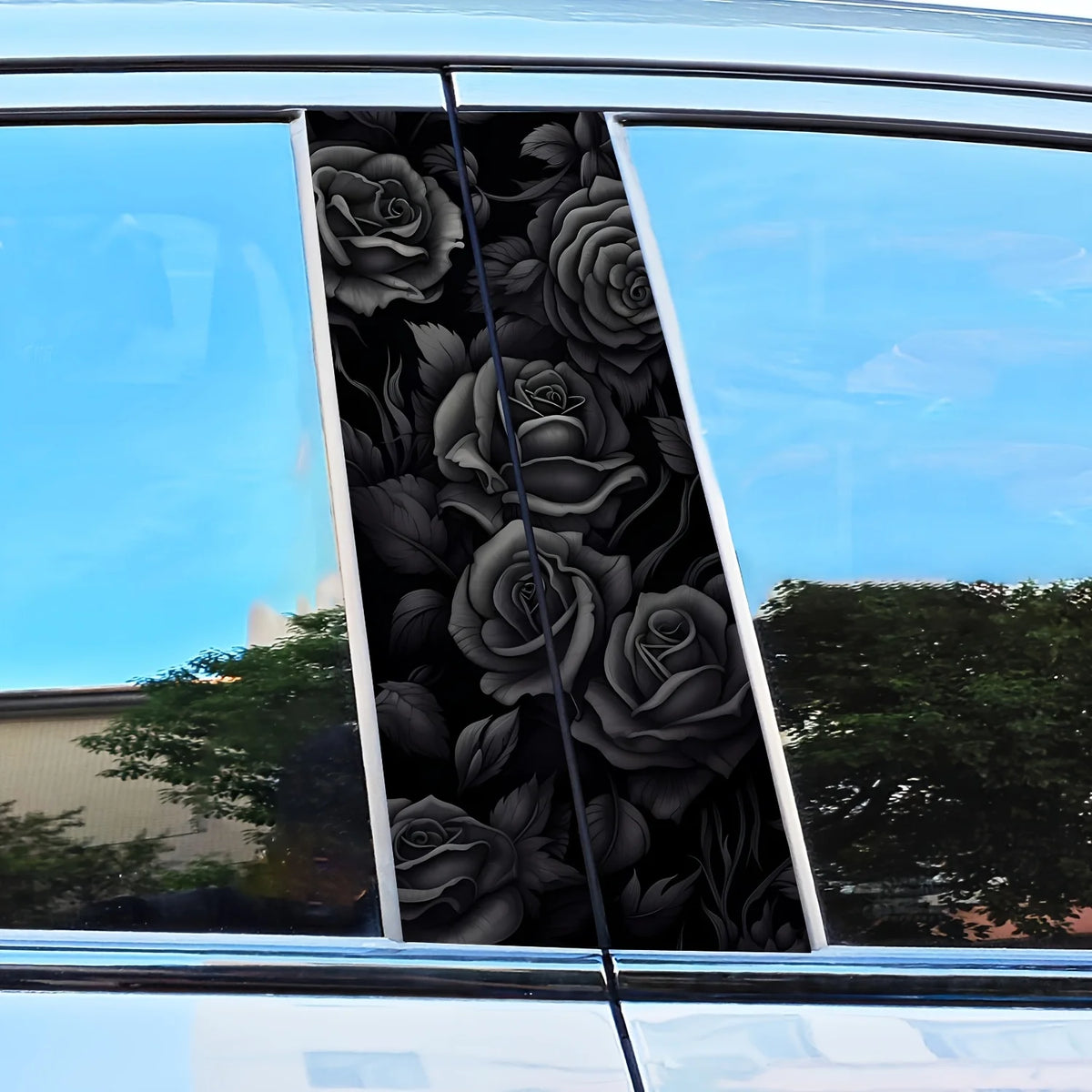 A close-up view of a black rose pattern decal applied to the B-pillar of a car window.