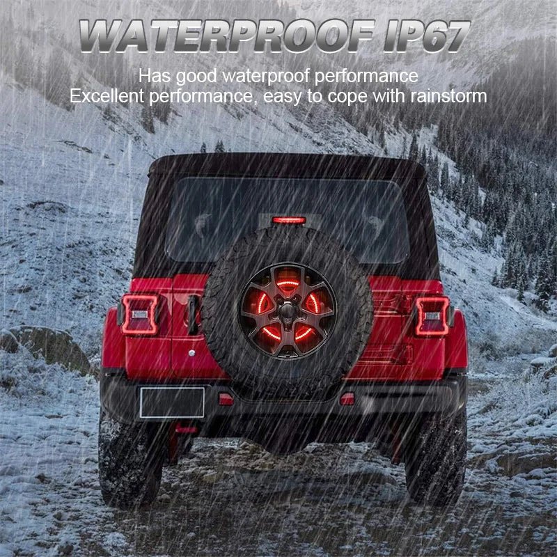 A red replacement spare tire brake light mounted on the rear of a Jeep Wrangler in a snowy outdoor setting.