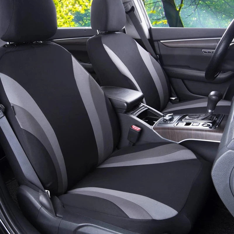 Interior view of a car seat with black and gray breathable fabric covers installed on the front seats.