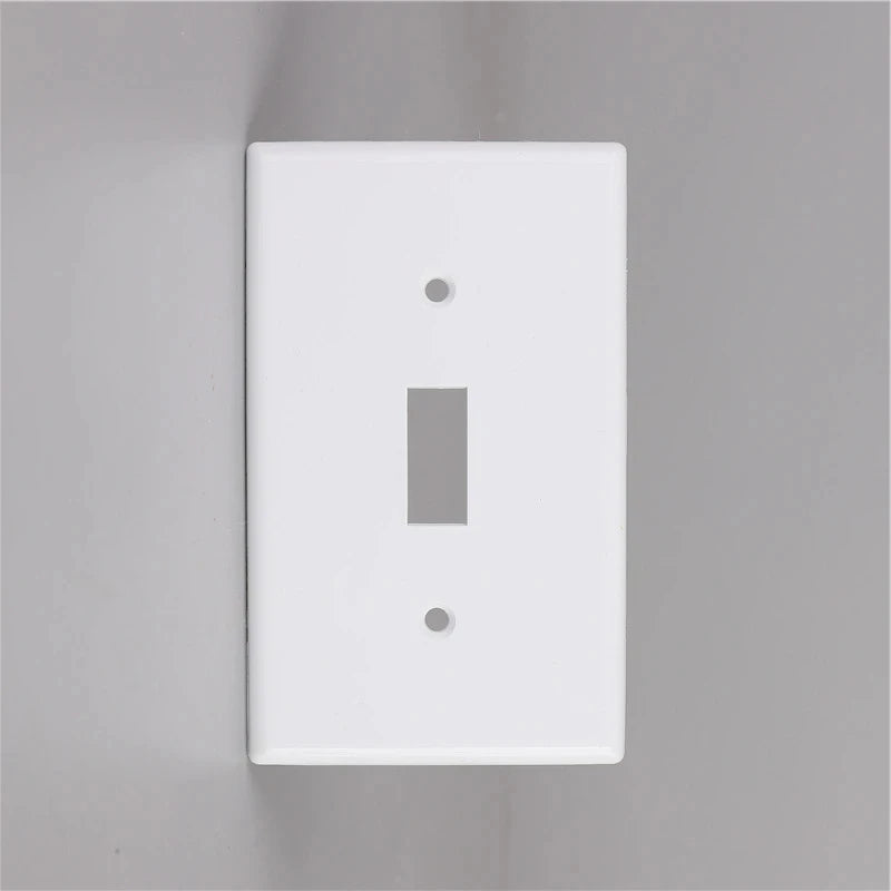 A white electrical light switch cover plate mounted on a gray wall.