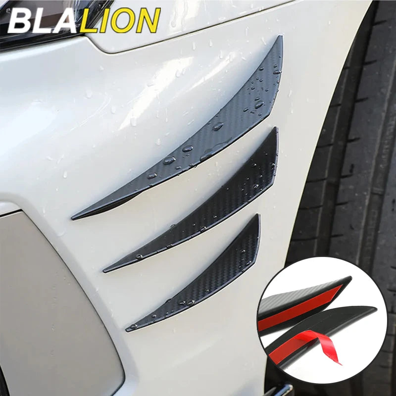 Black spoiler fins installed on a white car bumper.